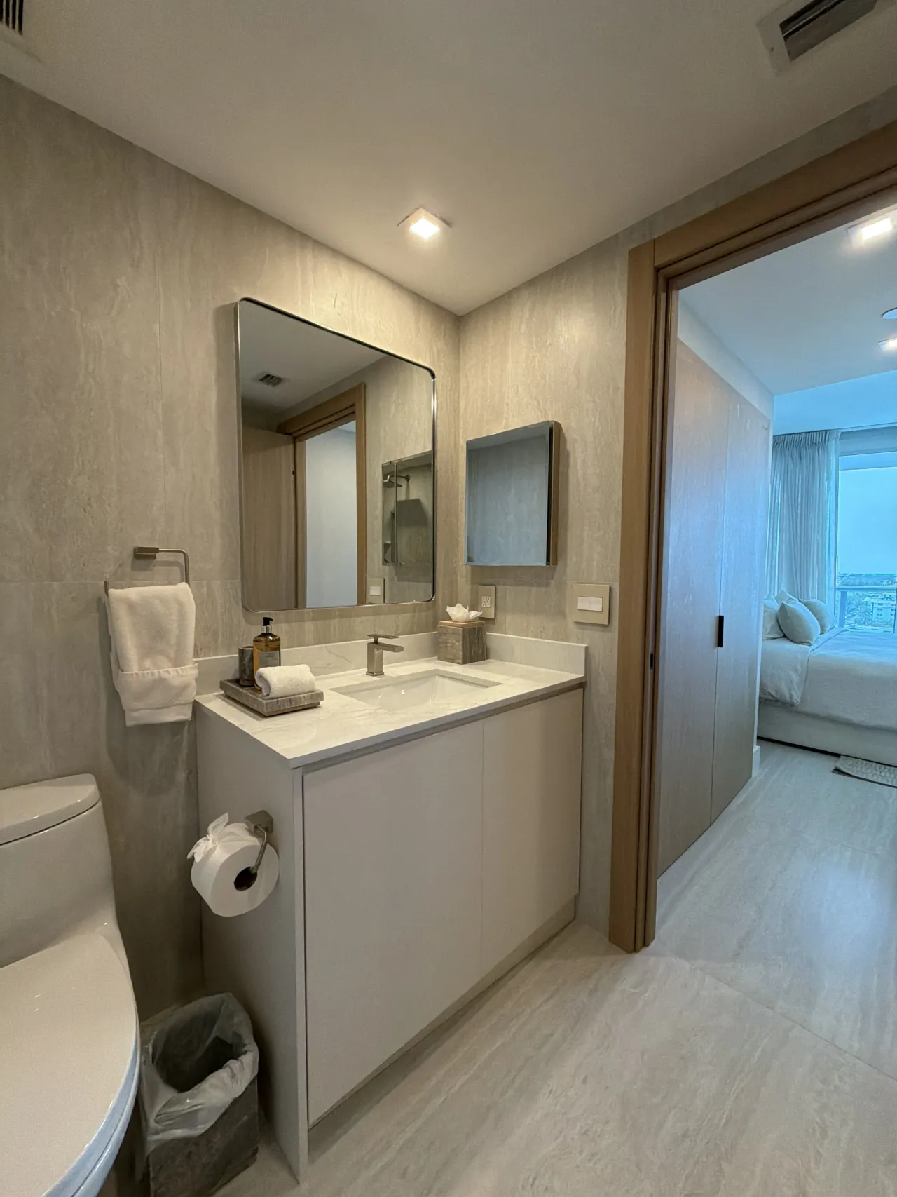 Bathroom vanity with a white cabinet base, a white stone countertop, and a large rounded-corner rectangular mirror