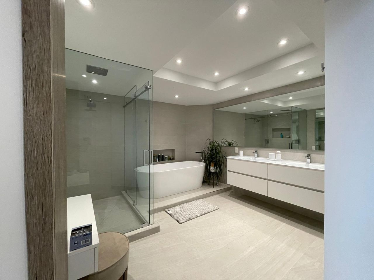 White double vanity bathroom with a tub, a glass shower, and the vanity together
