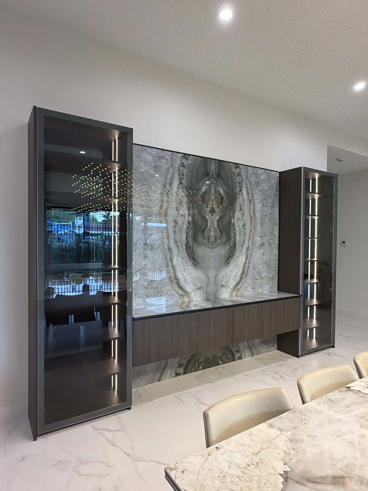 Bar area with stone slab facing and glass display towers, viewed from a different angle