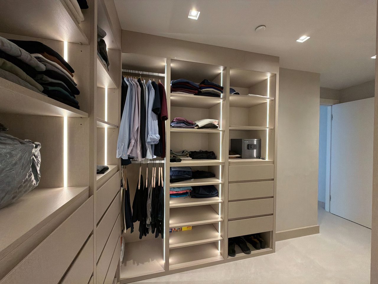 Gray melamine closet run with double hanging rails, LED-lit adjustable shelving, a four-drawer bank and open shoe storage below