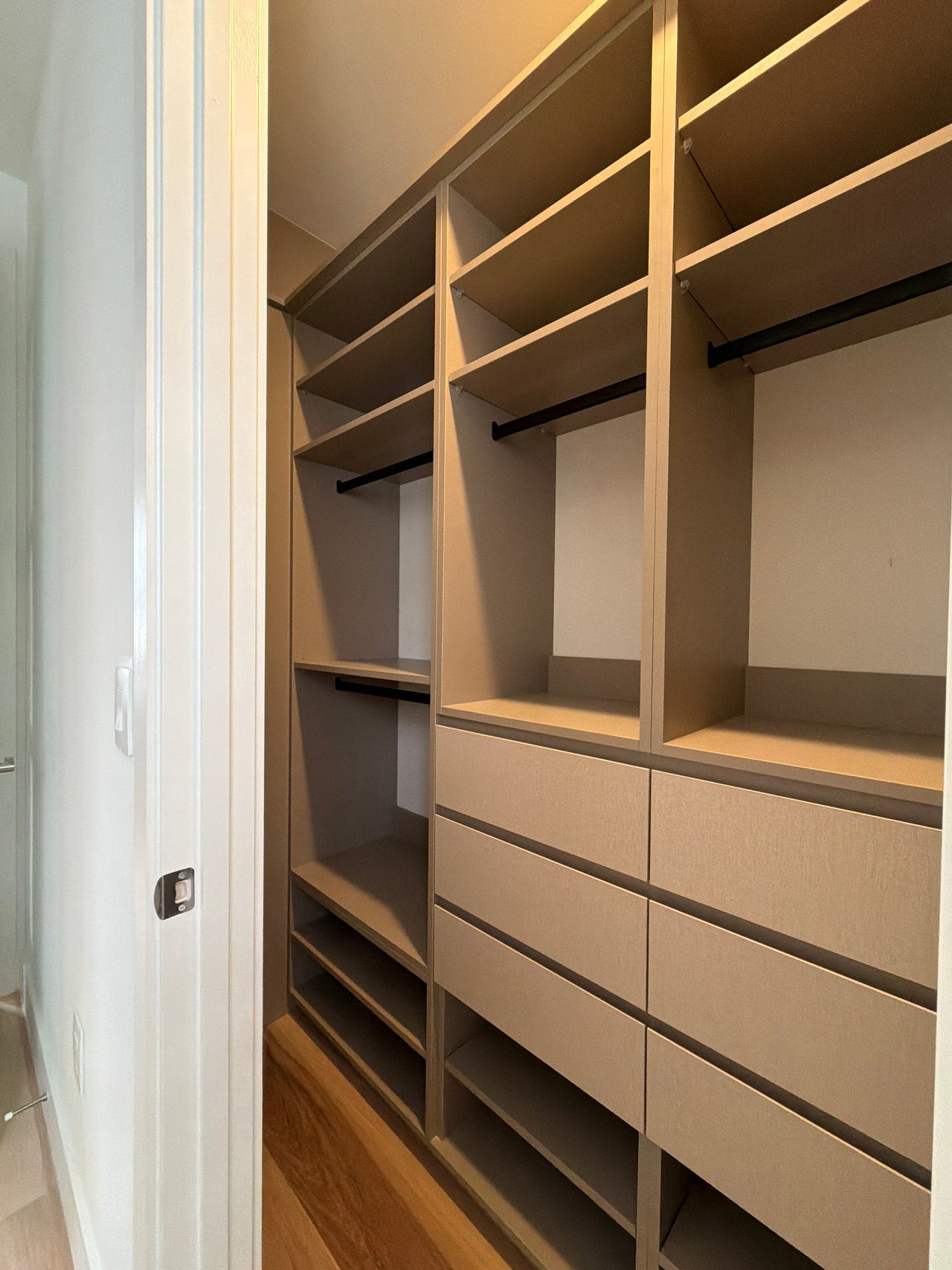 Tan/beige built-in shelving compartments with a woven-texture cabinet section