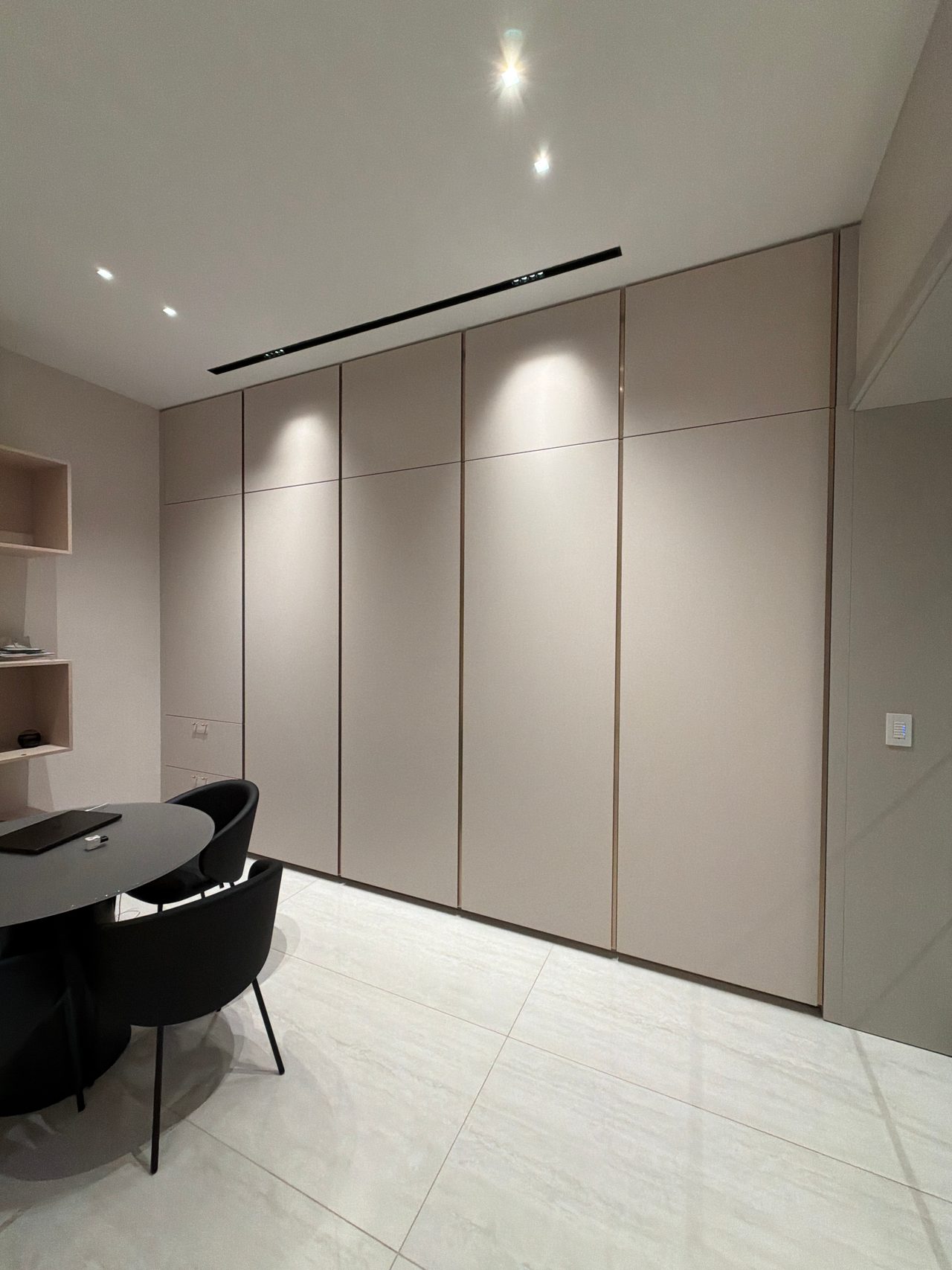 Taupe paneled wall with a chair nearby
