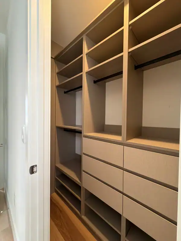 Tan/beige built-in shelving compartments with a woven-texture cabinet section